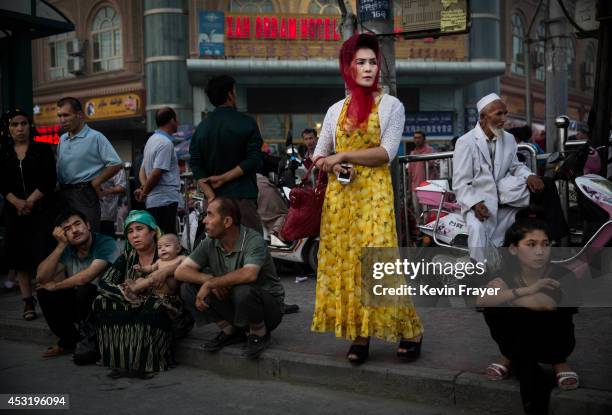 Uyghurs wait at a bus stop on July 27, 2014 in old Kashgar, Xinjiang Uyghur Autonomous Region, China. Nearly 100 people have been killed in unrest in...