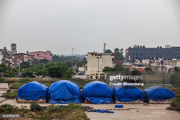 Sacks of wheat belonging to Food Corporation of India sit covered under tarps while being stored in the open at the Karnal Grain Market in Karnal...