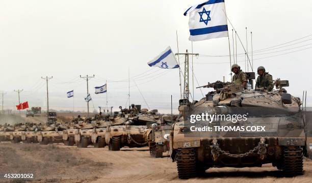 Israeli Merkava tanks drive near the border between Israel and the Gaza Strip as they return from the Hamas-controlled Palestinian coastal enclave on...