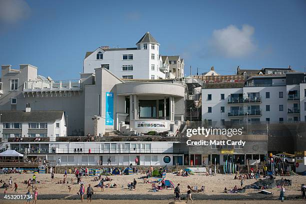 People gather on Porthmeor Beach overlooked by the Tate on August 4, 2014 in St Ives, Cornwall, England. A recent survey by the online hotel booking...