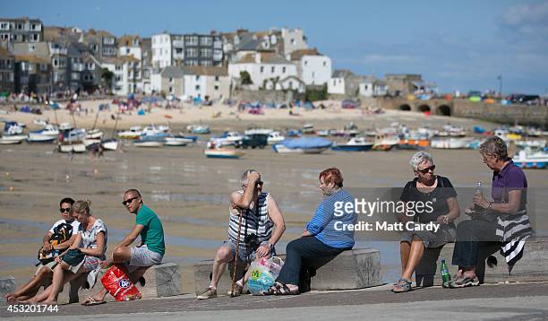 Visitors and holidaymakers enjoy the fine weather as they gather on the Harbour Beach on August 4, 2014 in St Ives, Cornwall, England. A recent...