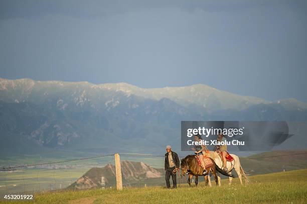 Tourist ride horses in Qinghai Lake region. Qinghai Lake,the sacred lake of the Tibetan Buddhism, is the largest salt lake in China, people cycling...