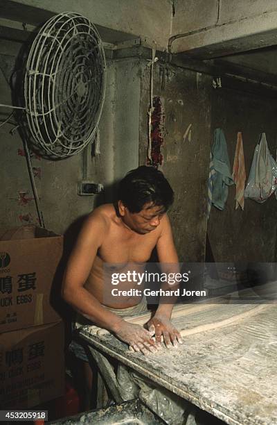 Man makes noodles in a sweet shop in the Walled City, Kowloon, Hong Kong.