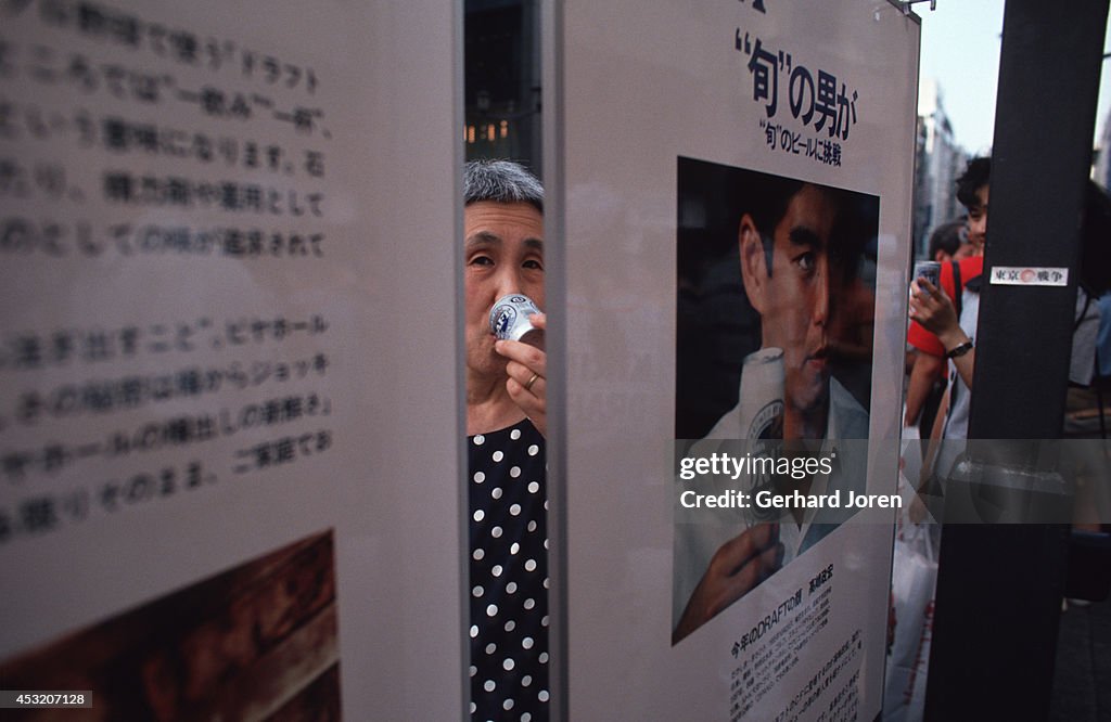 A woman tasting beer at a beer promotion on a main street in...