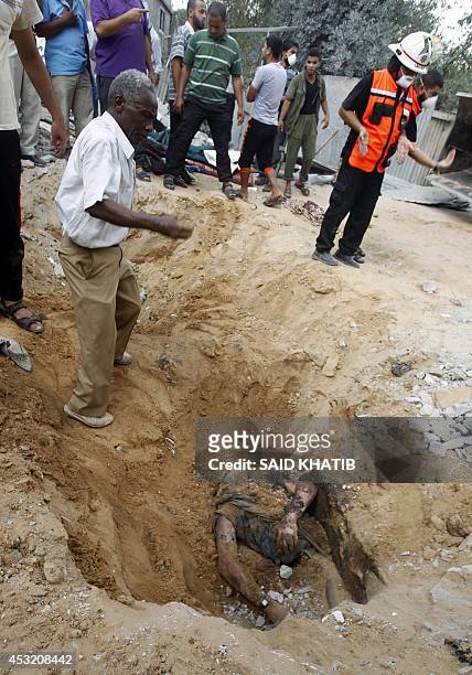 Rescue workers ready to remove the body a Palestinian man from under the rubble following an earlier Israeli air strike in Rafah in the southern Gaza...