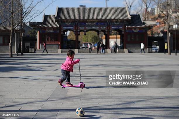 China-US-health-surrogacy,FEATURE by FELICIA SONMEZ A child plays at a park in Beijing on November 26, 2013. For decades China has been a top...