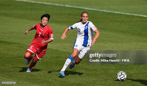 Nora Heroum of Finland is challenged by Choe Yun Gyong of Korea DPR during the FIFA U-20 Women's World Cup Canada 2014 Group A match between Finland...