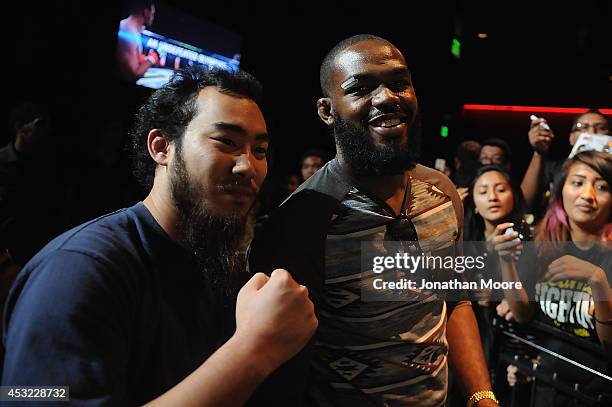Mixed martial artist Jon Jones poses with a fan after a UFC Q&A at LA Live on August 5, 2014 in Los Angeles, California.