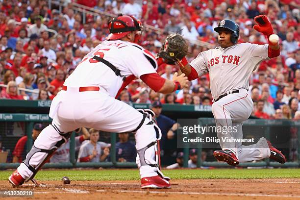 Yoenis Cespedes of the Boston Red Sox looks to score a run against A.J. Pierzynski of the St. Louis Cardinals in the second inning at Busch Stadium...