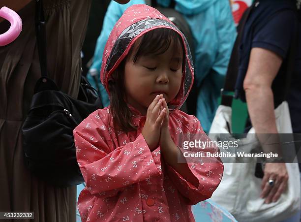 Child prays at the Hiroshima Peace Memorial Park on the day of the 69th anniversary of the atomic bombing of Hiroshima on August 6, 2014 in...