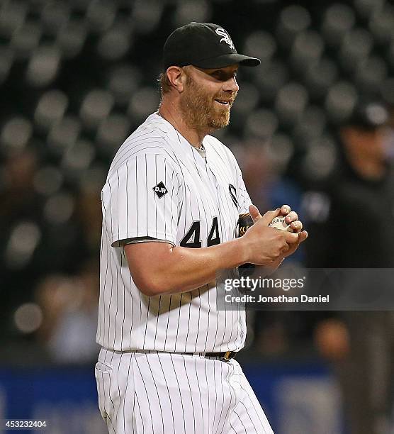 Adam Dunn of the Chicago White Sox smiles at teammates on the bench as he pitches in the 9th inning against the Texas Rangers at U.S. Cellular Field...