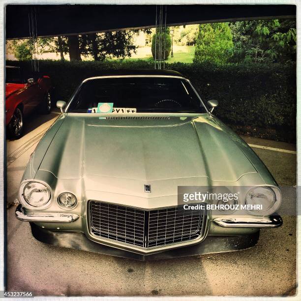 Picture taken with an Hipstamatic application shows a 1970 Chevrolet Camaro SS during a classic cars show at Saadabad palace in Tehran on August 5,...