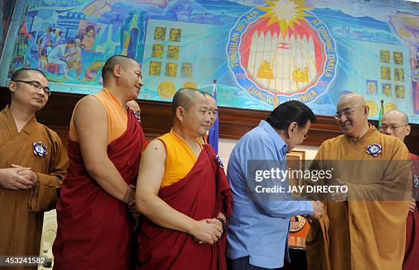 Buddhist monks from Hong kong shakes hands with former Philippine president and now Manila Mayor Joseph Estrada during a courtesy call and a press...