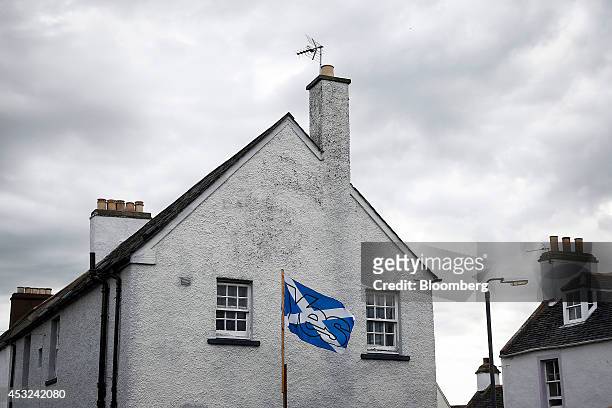 Yes' logo sits on a St. Andrew's or Saltire flag, the national flag of Scotland, as it flies from a pole in the garden of a home in Cromarty, U.K.,...