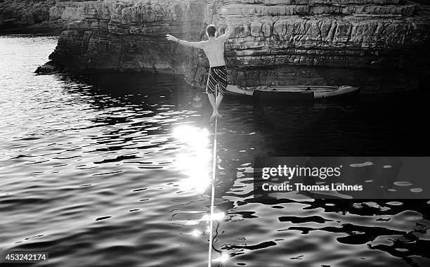 Climber walks over a 'Slackline' at the cliffs of Stoja on August 5, 2014 near Pula, Croatia. The area is known for 'Deep Water Soloing' , free...