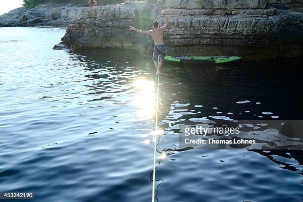 Climber walks over a 'Slackline' at the cliffs of Stoja on August 5, 2014 near Pula, Croatia. The area is known for 'Deep Water Soloing' , free...