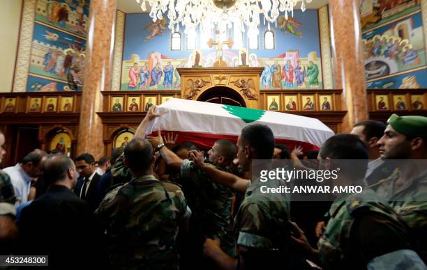 Lebanese army soldiers carry the coffin of army Capt. Danny Khairallah, killed in recent battles fighting jihadists in eastern Lebanon, into a church...