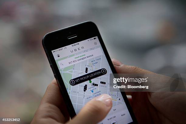 Th Uber Technologies Inc. Car service application is demonstrated for a photograph on an Apple Inc. IPhone in New York, U.S., on Wednesday, Aug. 6,...