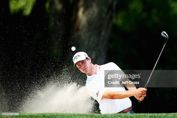 Harris English of the United States hits a shot from a greenside bunkerduring a practice round prior to the start of the 96th PGA Championship at...