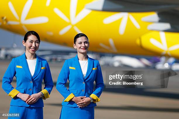 Vanilla Air cabin attendants pose for a photograph during a media preview at Narita Airport in Narita, Chiba Prefecture, Japan, on Tuesday, Dec. 3,...