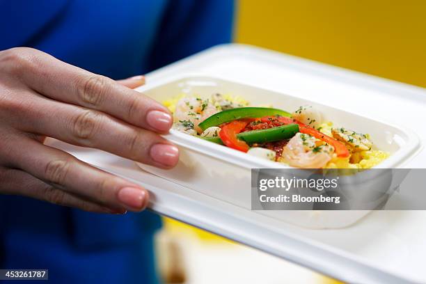 Cabin attendant displays an in-flight meal of paella-style rice for Vanilla Air during a media preview at Narita Airport in Narita, Chiba Prefecture,...