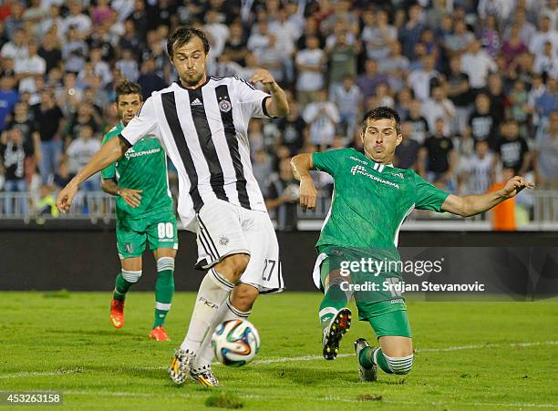 Danko Lazovic of FC Partizan Belgrade in action against Aleksandar Aleksandrov of FC Ludogorets Razgrad during the UEFA Champions League third...