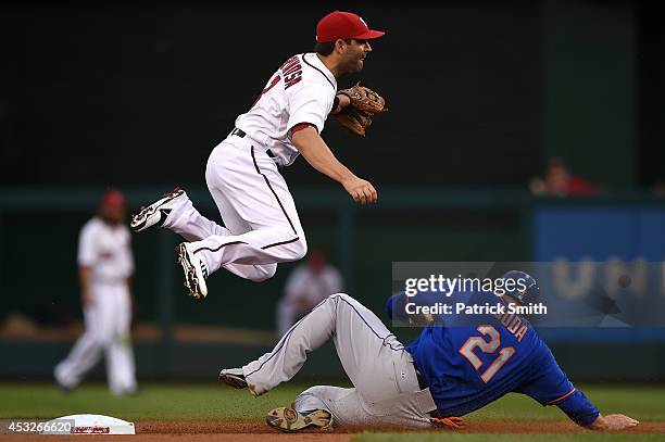 Danny Espinosa of the Washington Nationals turns the double play as Lucas Duda of the New York Mets slides underneath him in the second inning at...