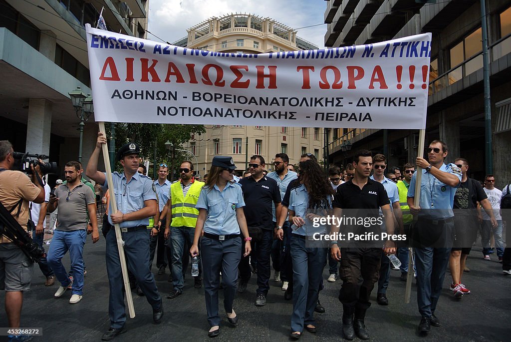 Demonstrators pass through the streets of Athens on their...