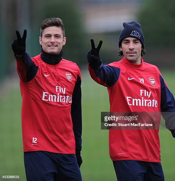 Arsenal's Olivier Giroud with ex player Robert Pires gesture before a training session at London Colney on December 3, 2013 in St Albans, England.