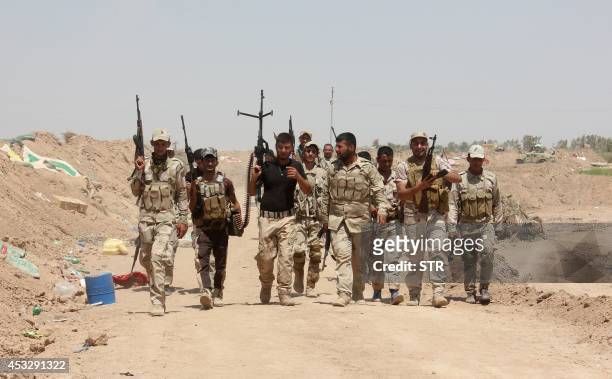Iraqi volunteers who joined government forces to fight against Sunni jihadist militants of the Islamic State hold a position at a checkpoint in...
