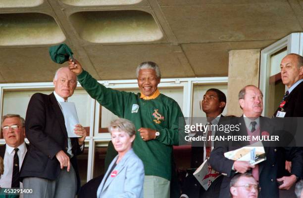 South African President Nelson Mandela wearing a Springbok jersey and cap waves upon arriving at Ellis Park in Johannesburg for the rugby World Cup...