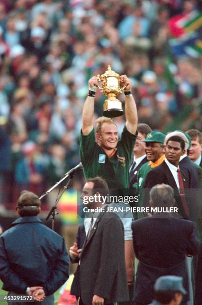 South African President Nelson Mandela wearing a Springbok jersey and cap celebrates on June 24, 1995 as Springbok skipper Francois Pienaar...