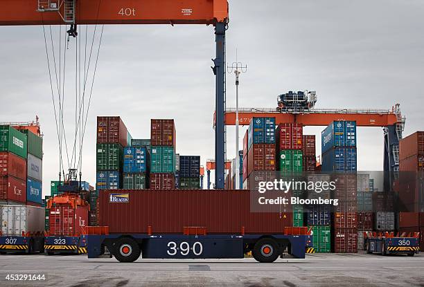 Automated guided vehicles transport shipping containers as gantry cranes operate on the dock at the Euromax Terminal in the Port of Rotterdam in...