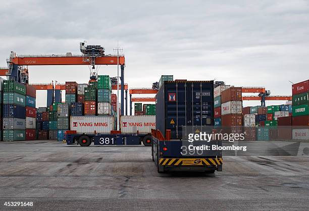 Automated guided vehicles transport shipping containers as gantry cranes operate on the dock at the Euromax Terminal in the Port of Rotterdam in...