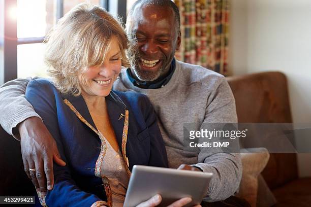cheerful middle aged couple in a restaurant using digital tablet - instagram husband stock pictures, royalty-free photos & images
