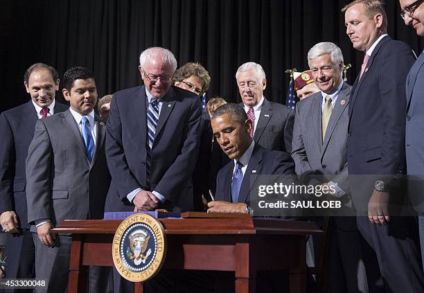 President Barack Obama signs House Resolution 3230, the Veterans Access to Care through Choice, Accountability, and Transparency Act of 2014, during...