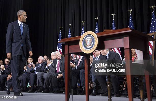 President Barack Obama walks to sign the Veterans Access to Care through Choice, Accountability, and Transparency Act of 2014, during a signing...