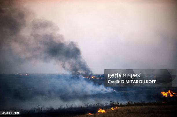 Smoke billows from the flaming debris of a crashed Ukrainian fighter jet near the village of Zhdanivka, some 40 kilometres northeast of the rebel...