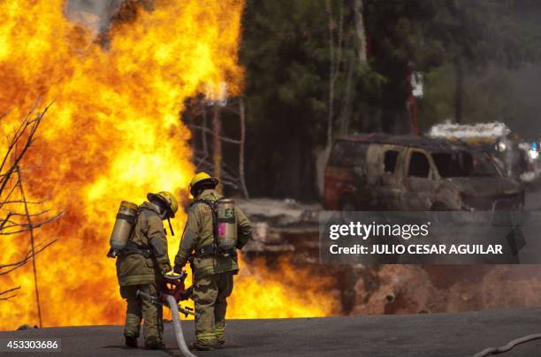 Firefighters try to extinguish a fire caused by the explosion of a gas pipeline after the collapse of an under-construction building in Monterrey,...
