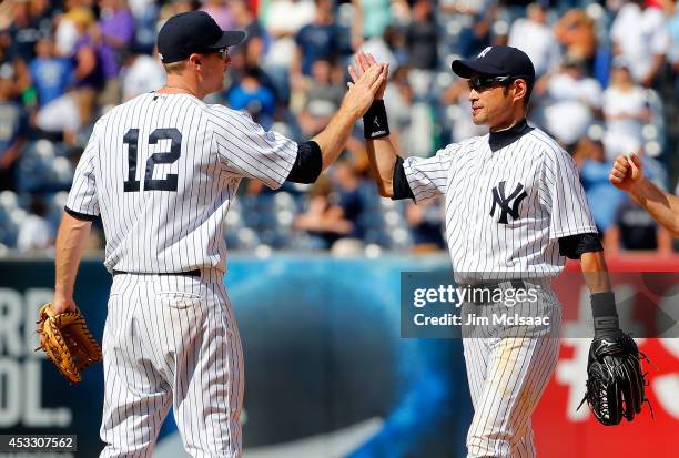 Ichiro Suzuki and Chase Headley of the New York Yankees celebrate after defeating the Detroit Tigers at Yankee Stadium on August 7, 2014 in the Bronx...