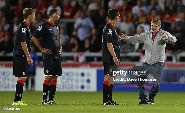 Fan runs on to the pitch to hug Gary Neville during the match between Salford City and the Class of '92 XI at AJ Bell Stadium on August 7, 2014 in...