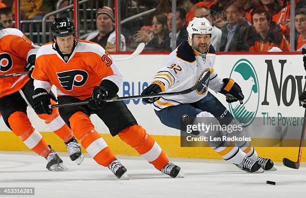 Jay Rosehill of the Philadelphia Flyers battles for the puck against John Scott of the Buffalo Sabres on November 21, 2013 at the Wells Fargo Center...