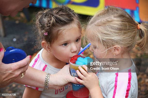 Twins Jocelyn and Julianne Waters sample a slush drink at the Iowa State Fair on August 7, 2014 in Des Moines, Iowa. The fair opened today and will...