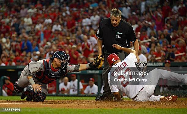 Christian Vazquez of the Boston Red Sox misses the tag as Jhonny Peralta of the St. Louis Cardinals scores during the first inning at Busch Stadium...