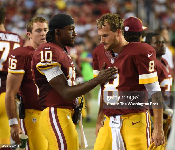 Washington Redskins quarterback Robert Griffin III consoles Washington Redskins quarterback Kirk Cousins after Cousins' offense was forced to attempt...