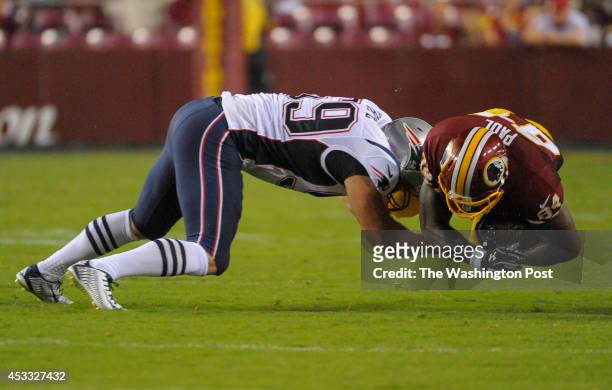 New England Patriots linebacker Chris White hits an airborne Washington Redskins tight end Niles Paul as he comes up one yard short of a first down...