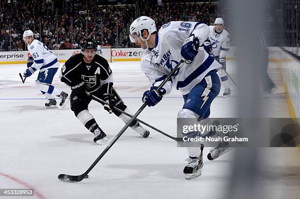 Teddy Purcell of the Tampa Bay Lightning skates with the puck against Anze Kopitar of the Los Angeles Kings at Staples Center on November 19, 2013 in...