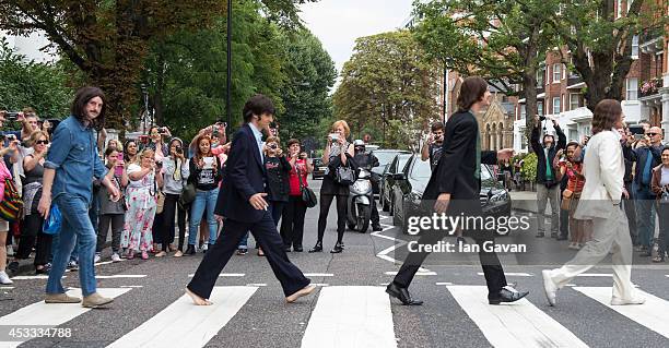 The cast of the West End Beatles show "Let It Be" cross the zebra crossing outside Abbey Road Studios during a photocall to celebrate The Beatles...