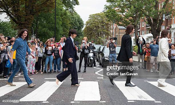 The cast of the West End Beatles show "Let It Be" cross the zebra crossing outside Abbey Road Studios during a photocall to celebrate The Beatles...