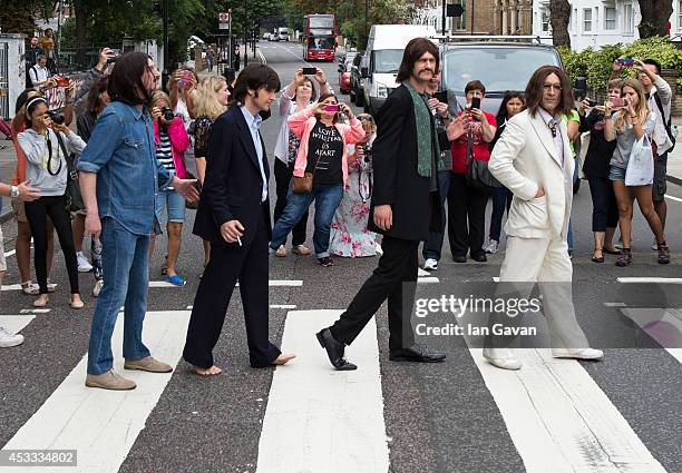 The cast of the West End Beatles show "Let It Be" cross the zebra crossing outside Abbey Road Studios during a photocall to celebrate The Beatles...